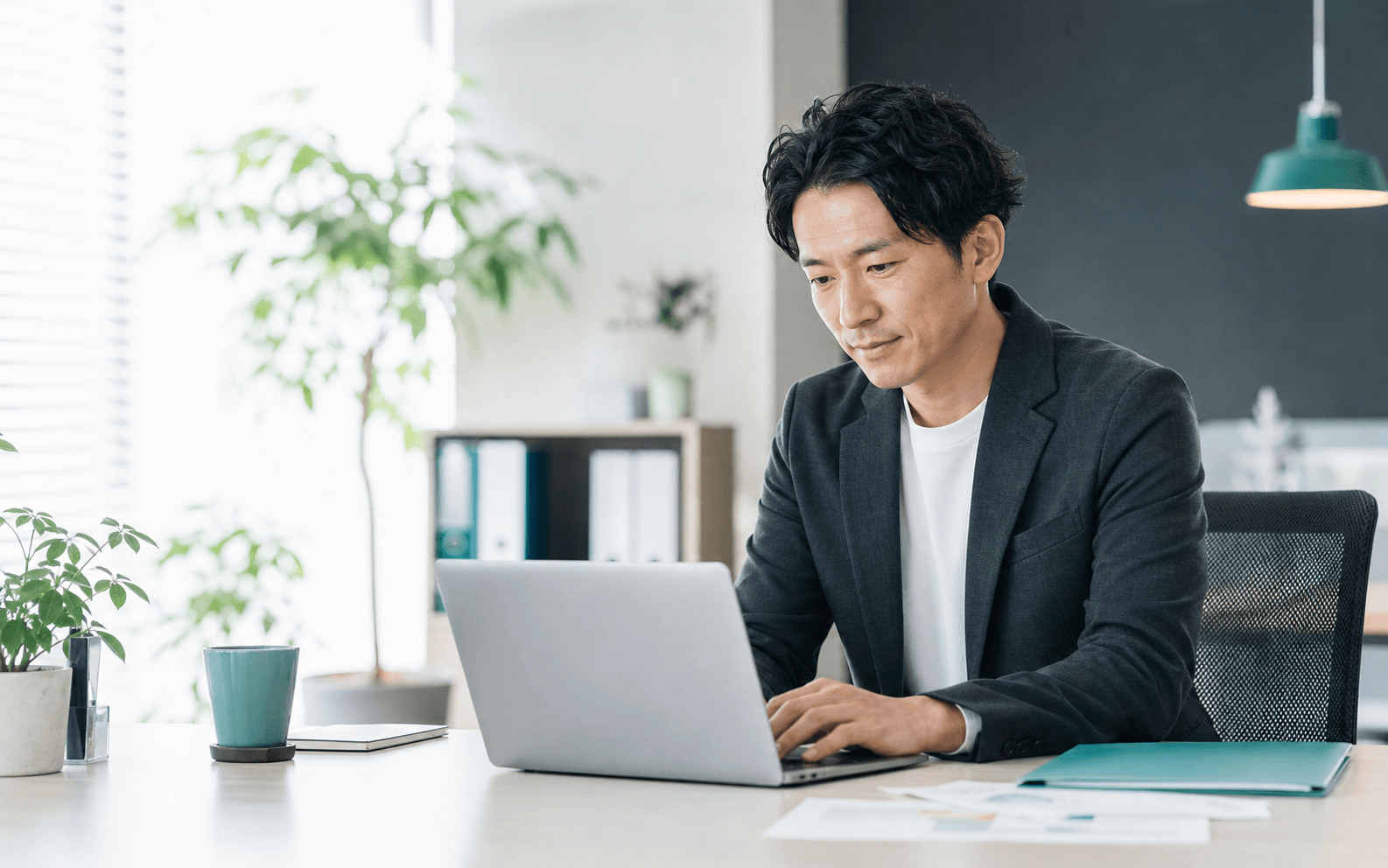 ノートPCでイベント準備を進めるビジネスパーソン